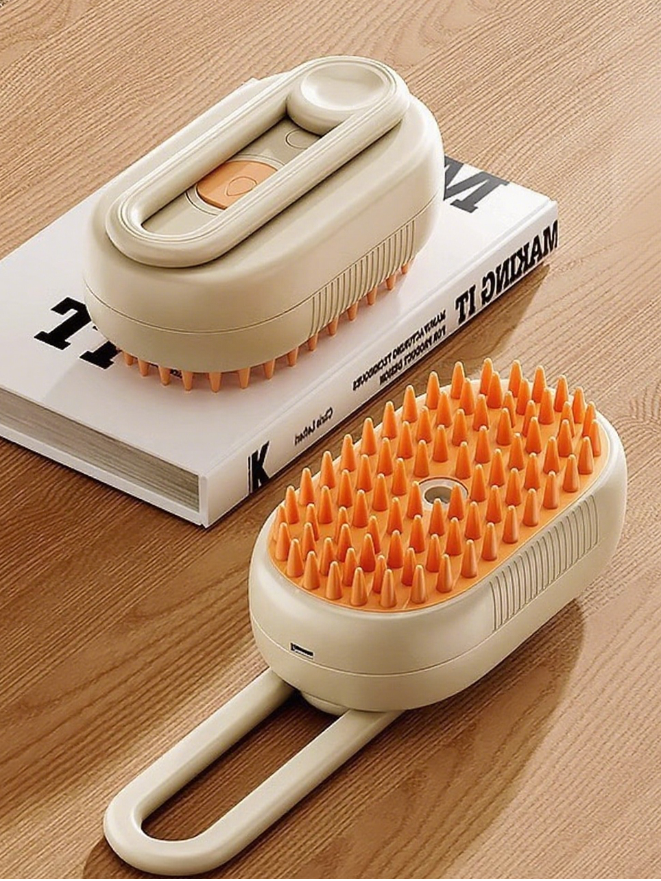 Two beige and orange scrubbing brushes on a wooden surface with a book underneath.