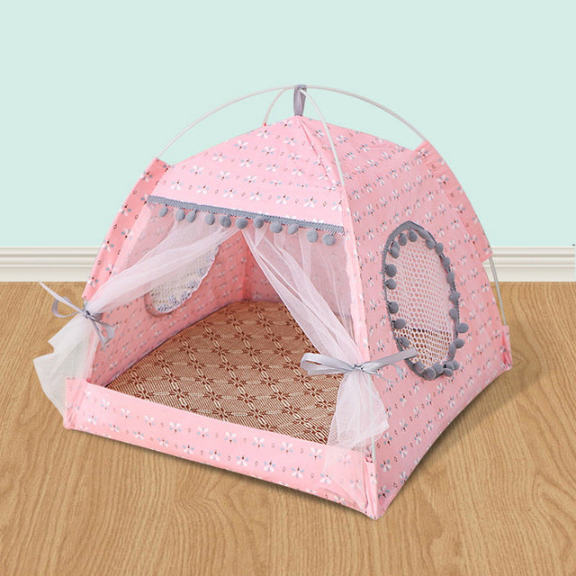 Pink pet tent with decorative elements on a wooden floor and light blue wall background