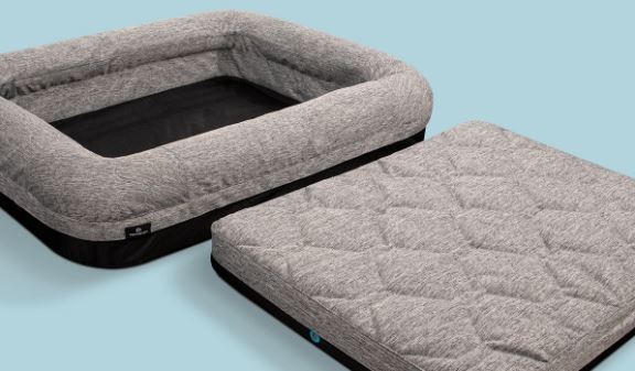 Gray pet bed with quilted cover on a light blue background