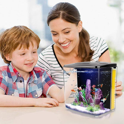 Woman and child looking at a small aquarium with fish and coral.
