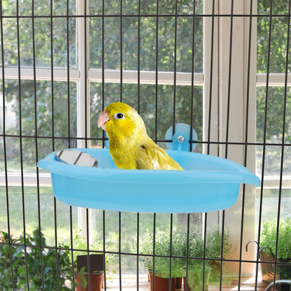 Bird perched on a blue platform inside a cage with greenery outside.