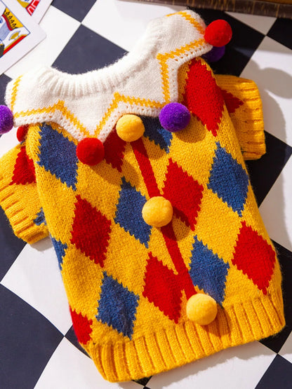 Colorful knitted sweater with diamond pattern and pom-poms on a checkered background