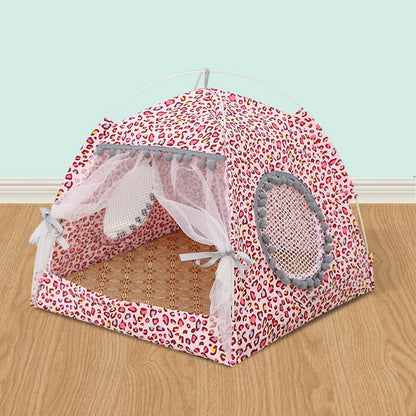 Pink pet tent with leopard print design on a wooden floor.