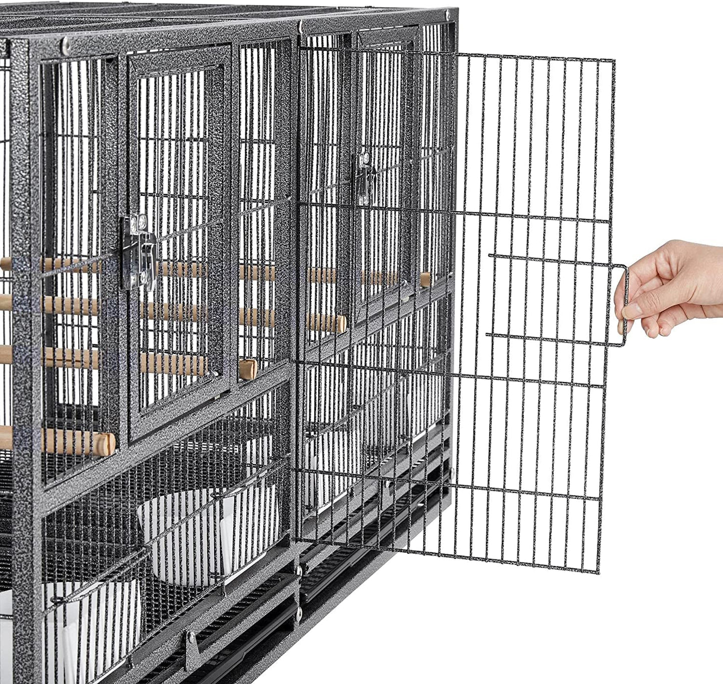 Large metal bird cage with a hand opening one of the doors on a white background