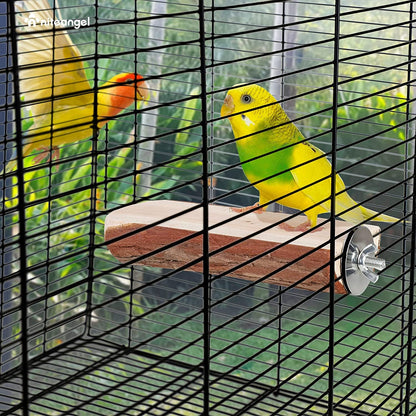 Two parrots in a cage with a wooden perch and greenery outside.