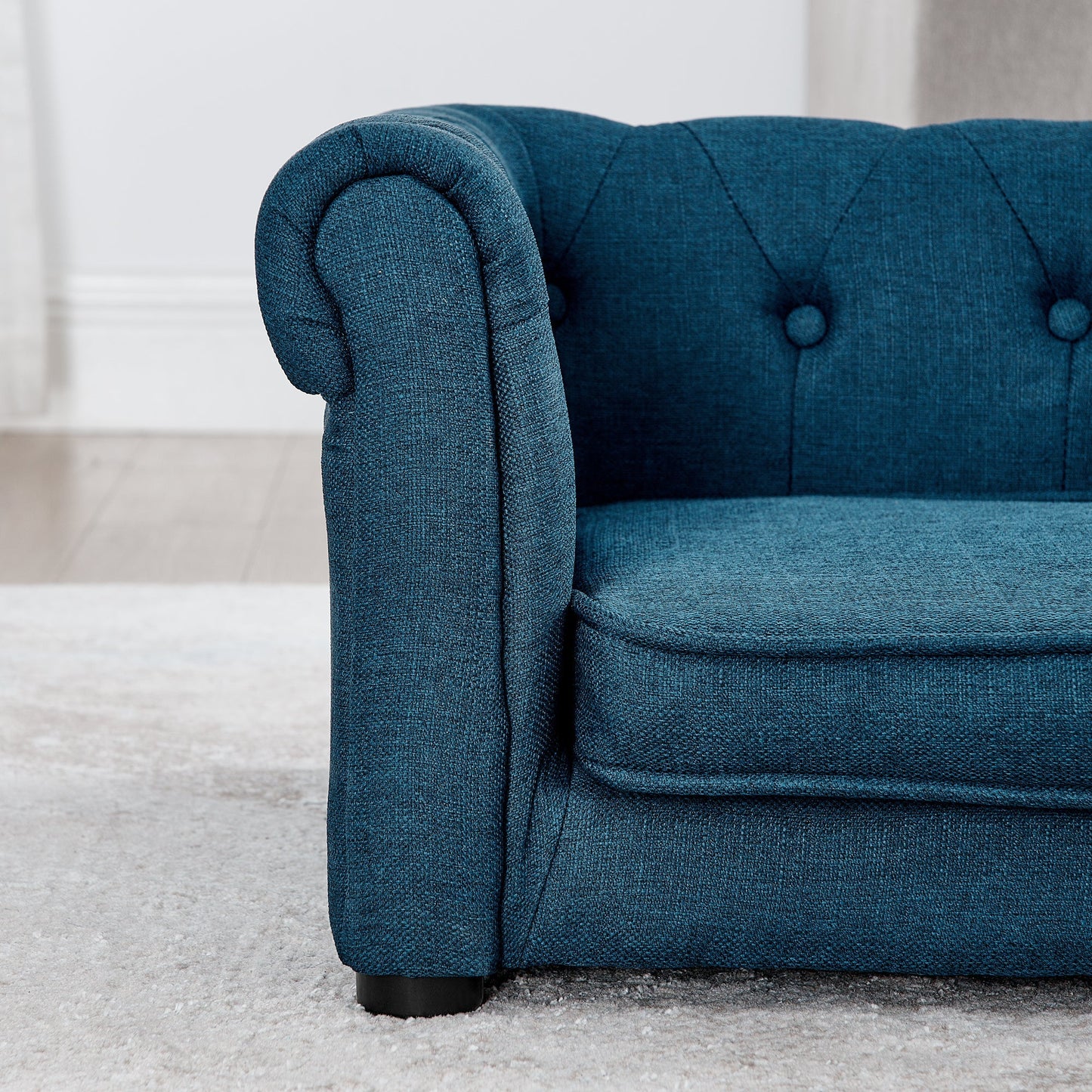 Blue upholstered chair with tufted backrest on a light gray carpet
