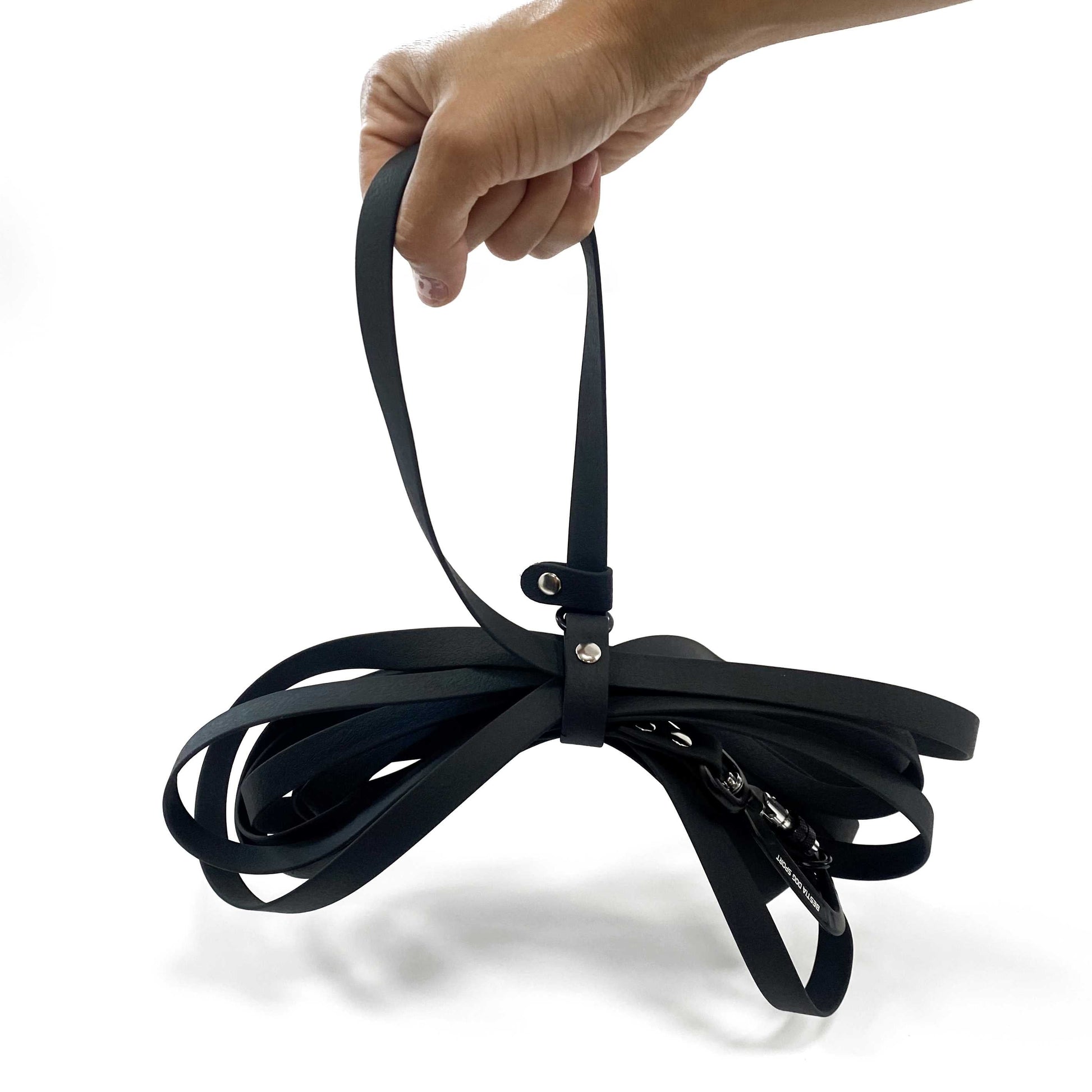 Black dog leash with a hand holding it on a white background