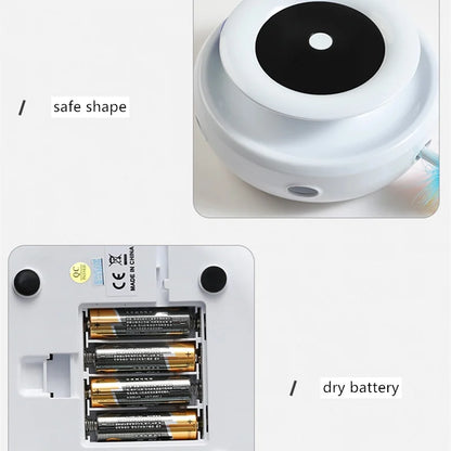 Small White Device with Black Circular Component and Batteries on a light gray background.