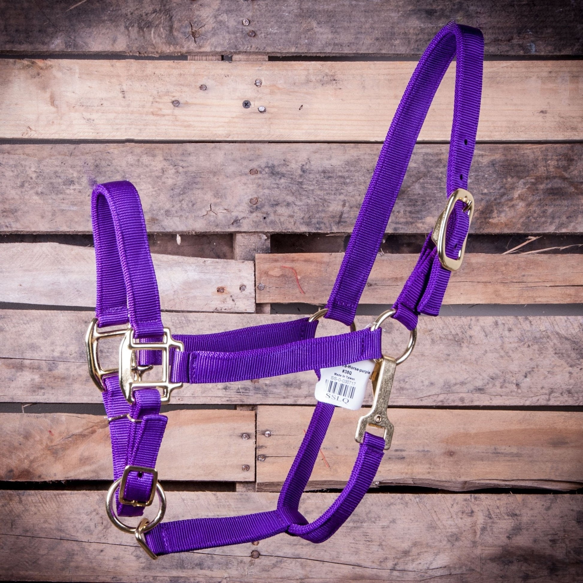 Purple horse halter with gold hardware on a wooden background