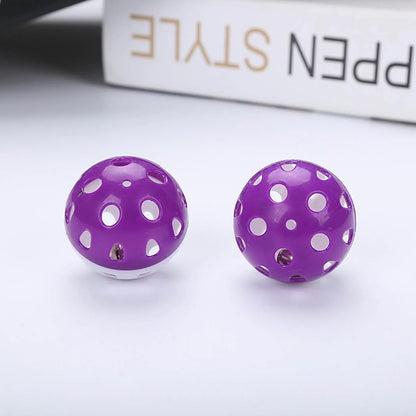 Two Purple Cat Ball Toys on a white surface with a blurred background.
