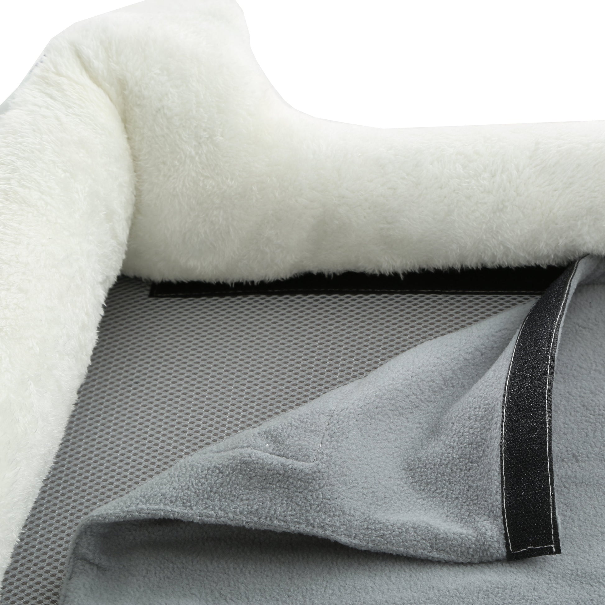 Close-up of a textured blanket with a soft white surface and gray mesh backing.