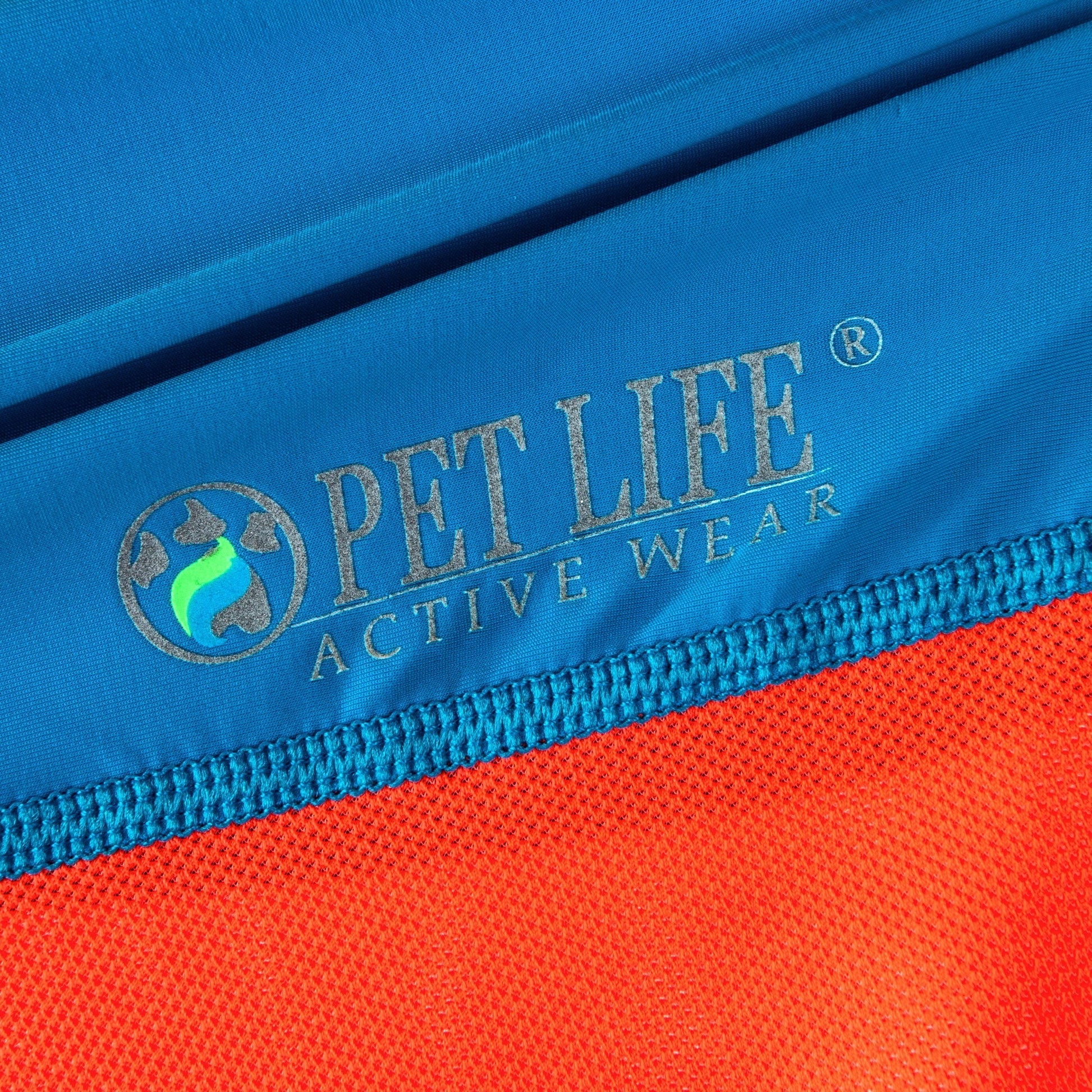 Close-up of Pet Life Active Wear logo on a blue and orange fabric background