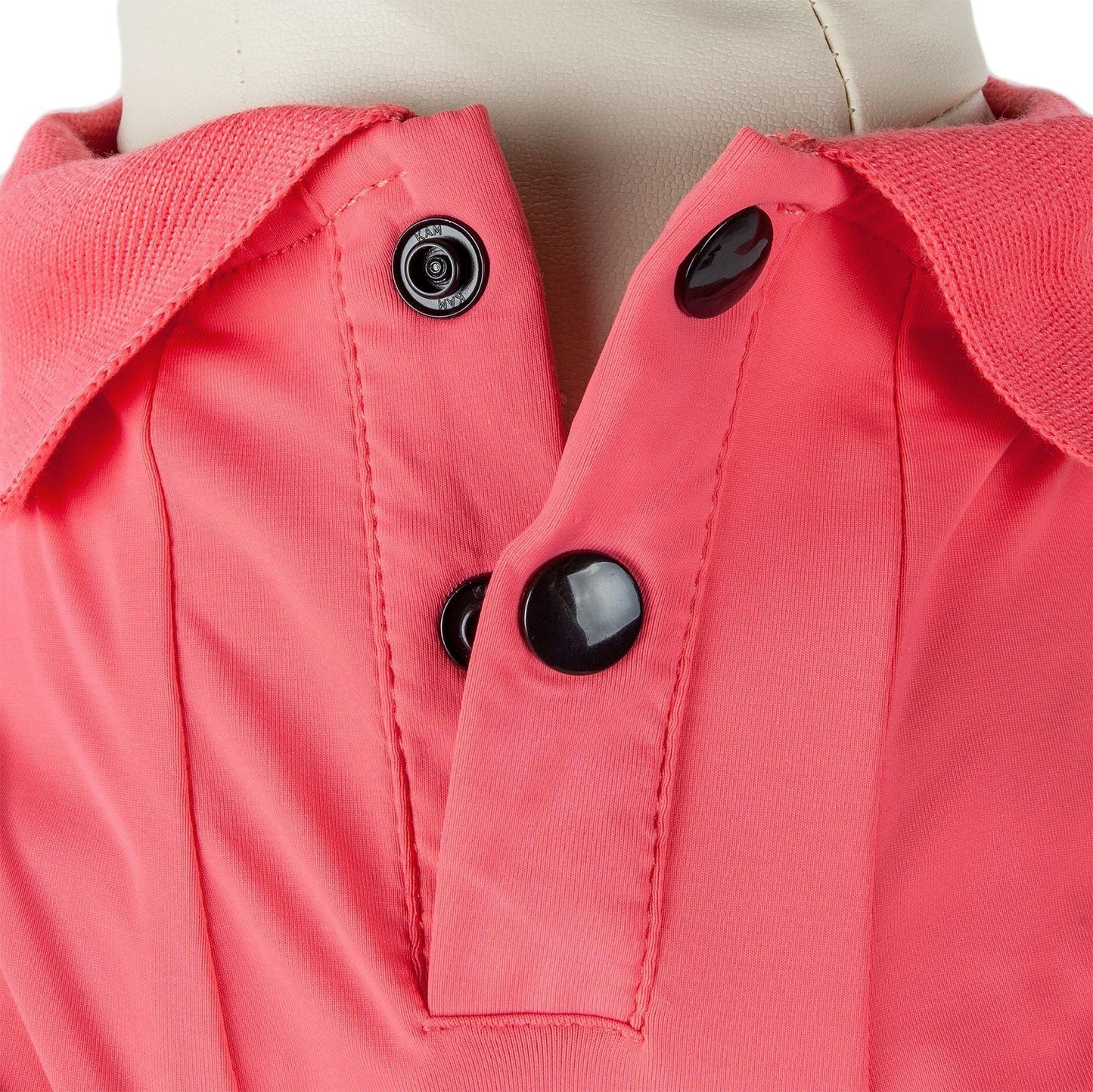 Close-up of a pink jacket with black buttons on a mannequin.