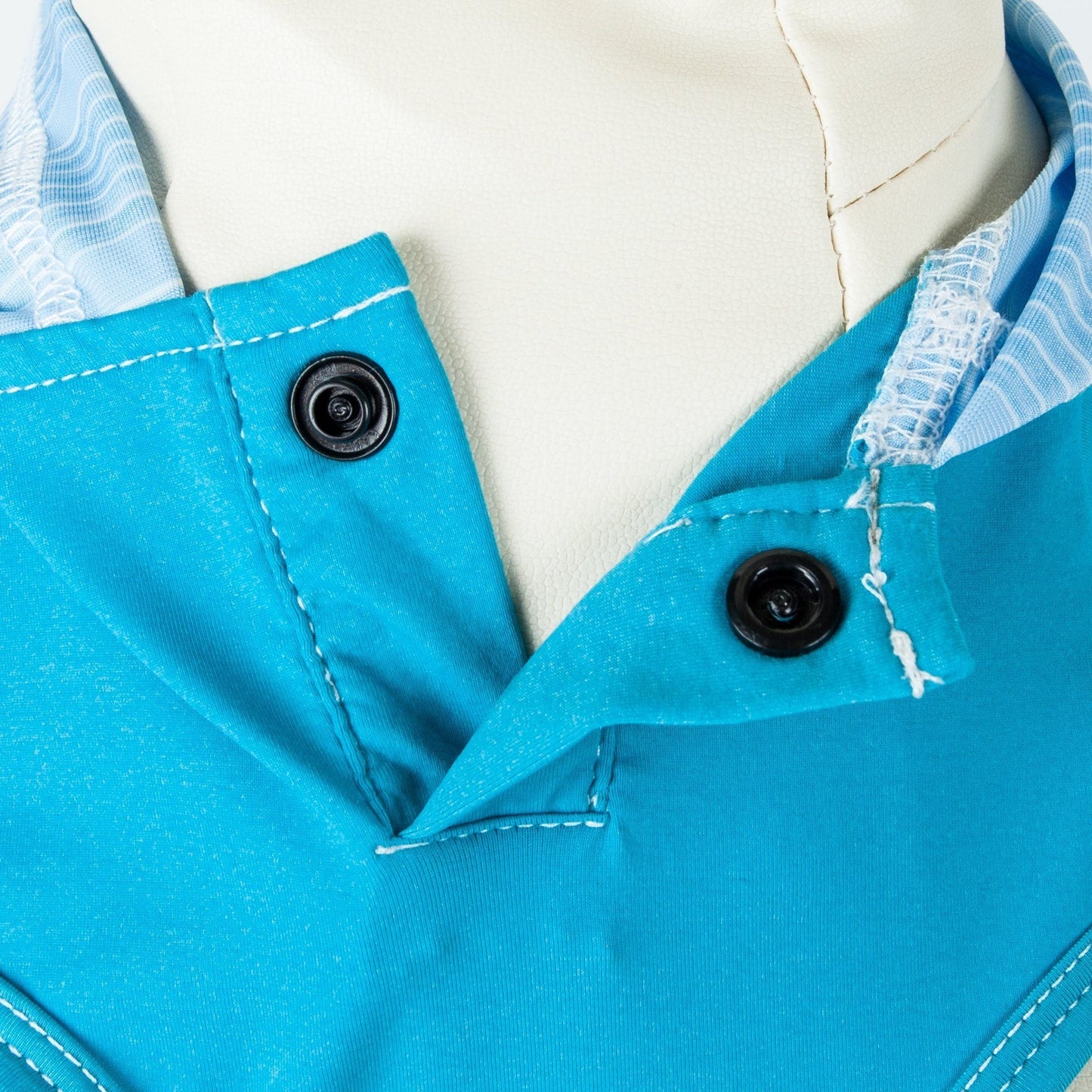 Close-up of a blue garment with buttons on a white background