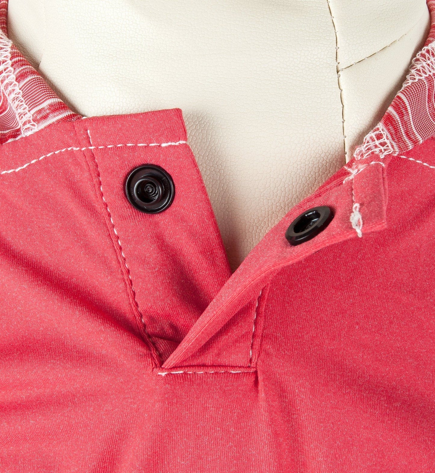 Close-up of a red garment with buttons on a white background