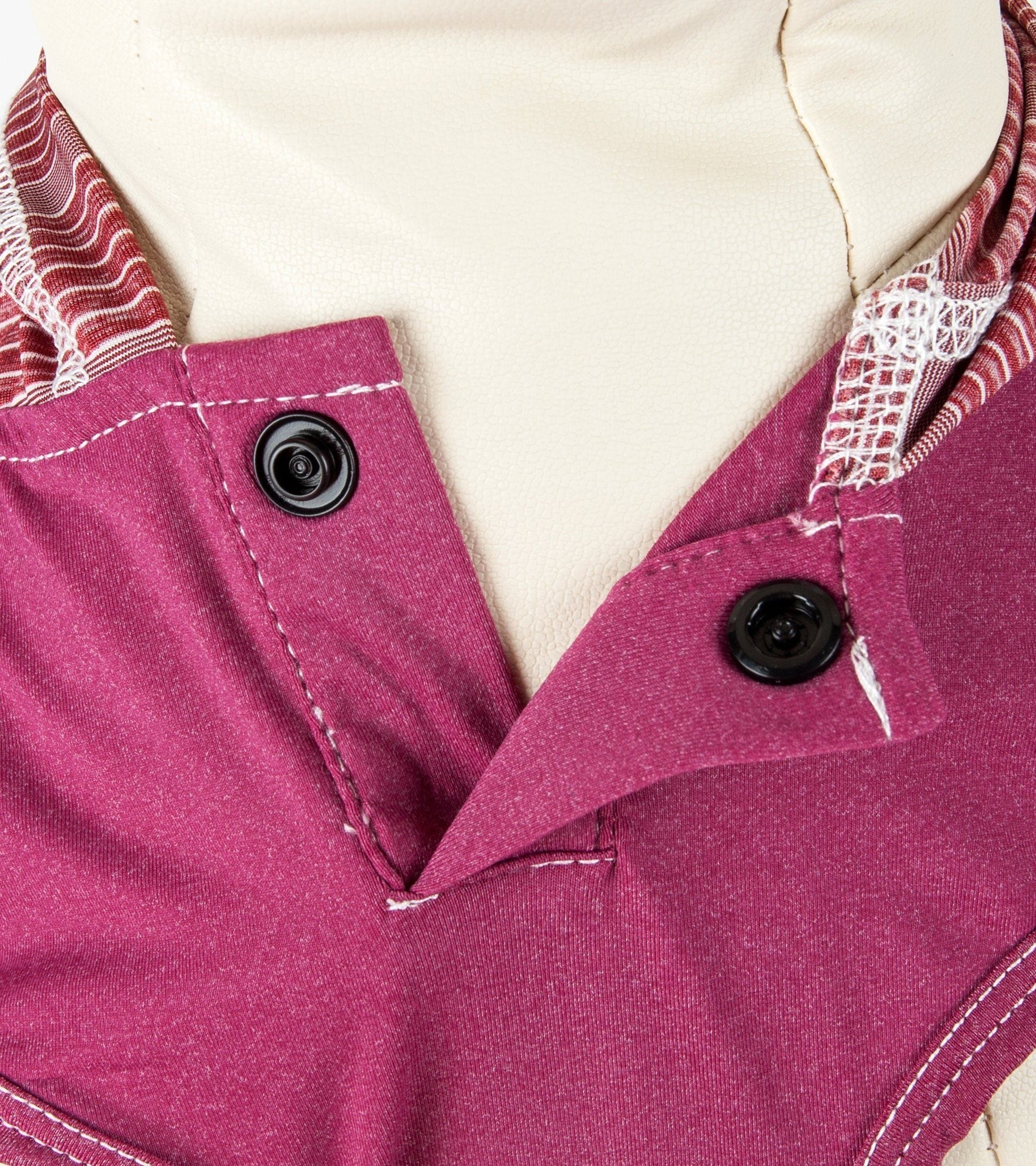 Close-up of a pink garment with buttons and a white background