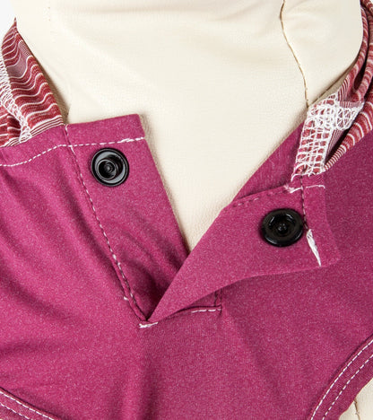 Close-up of a pink garment with buttons and a white background