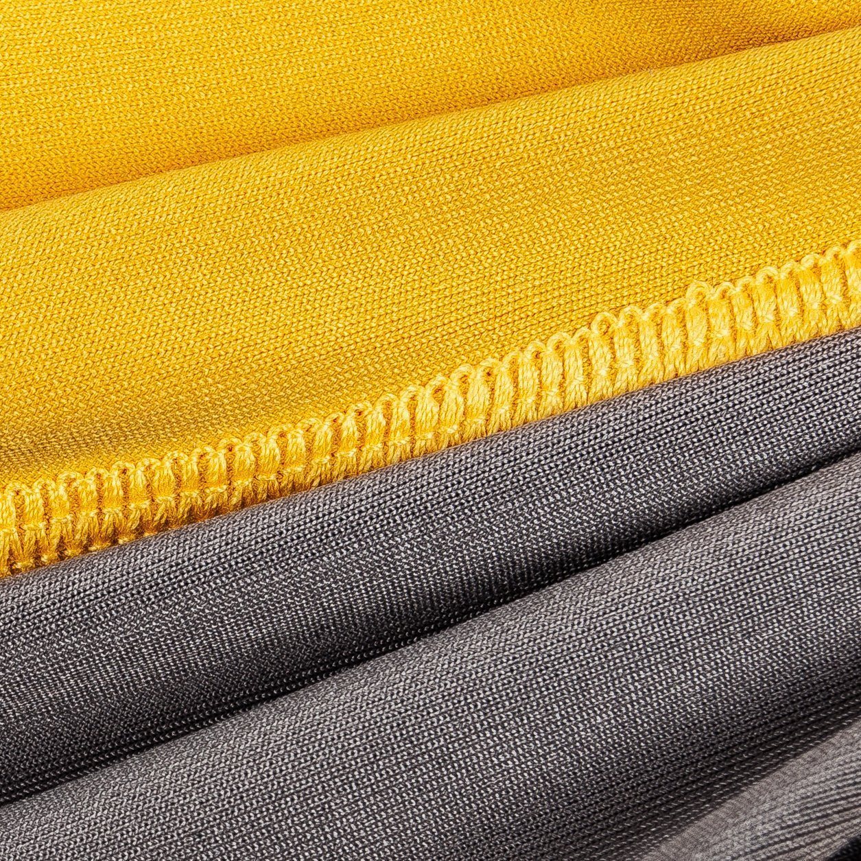 Close-up of yellow fabric with a zipper and gray fabric underneath