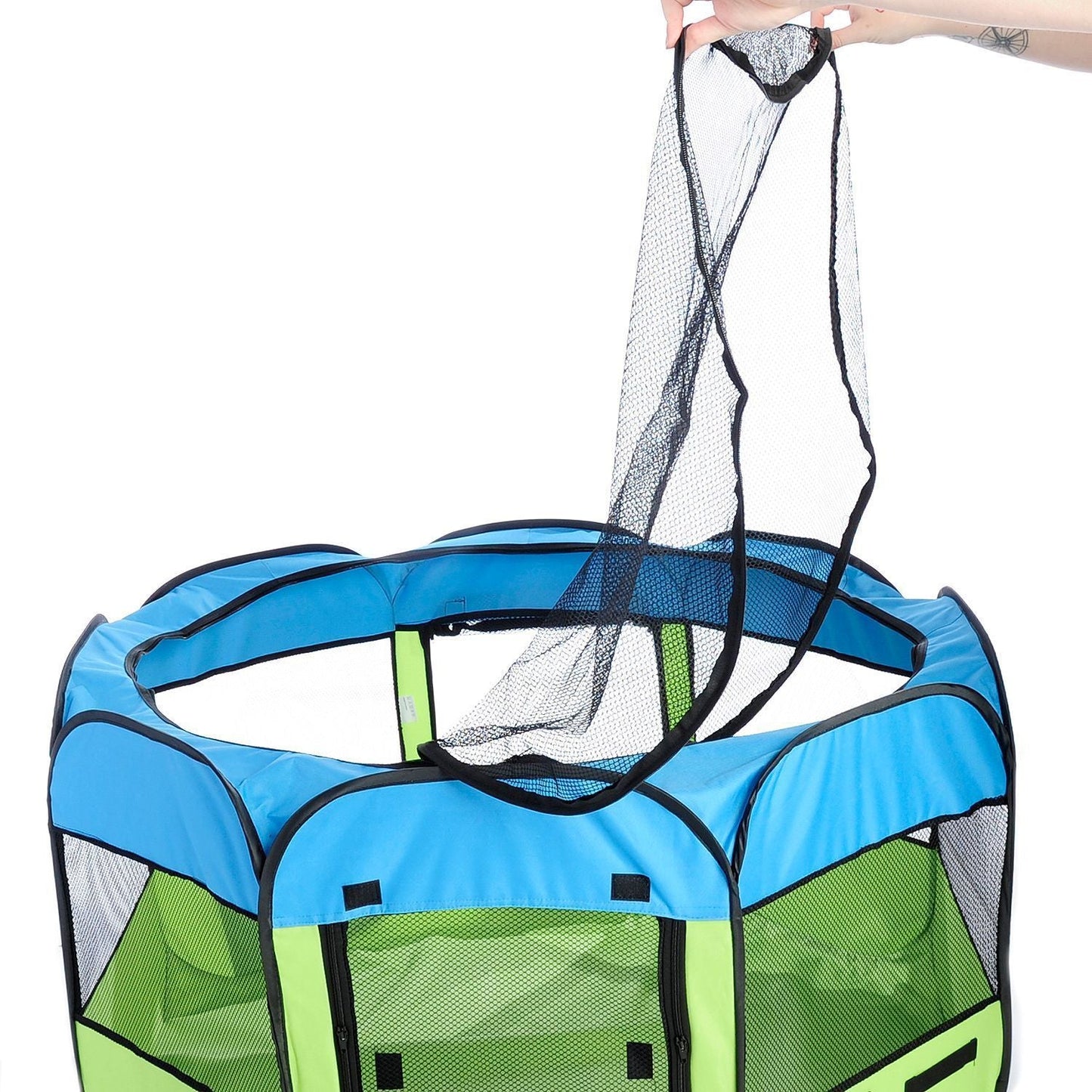 Green and blue playpen with a netting door held open by a hand on a white background