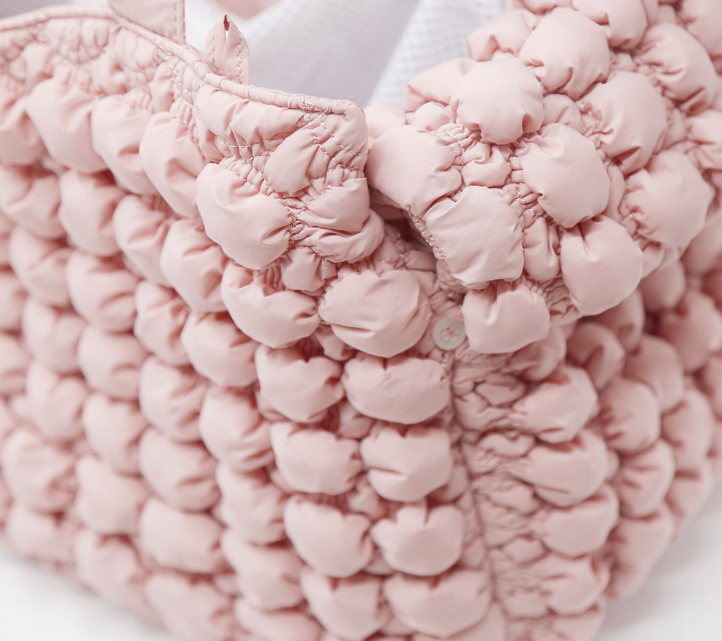 Close-up of a pink textured bag with a blurred background
