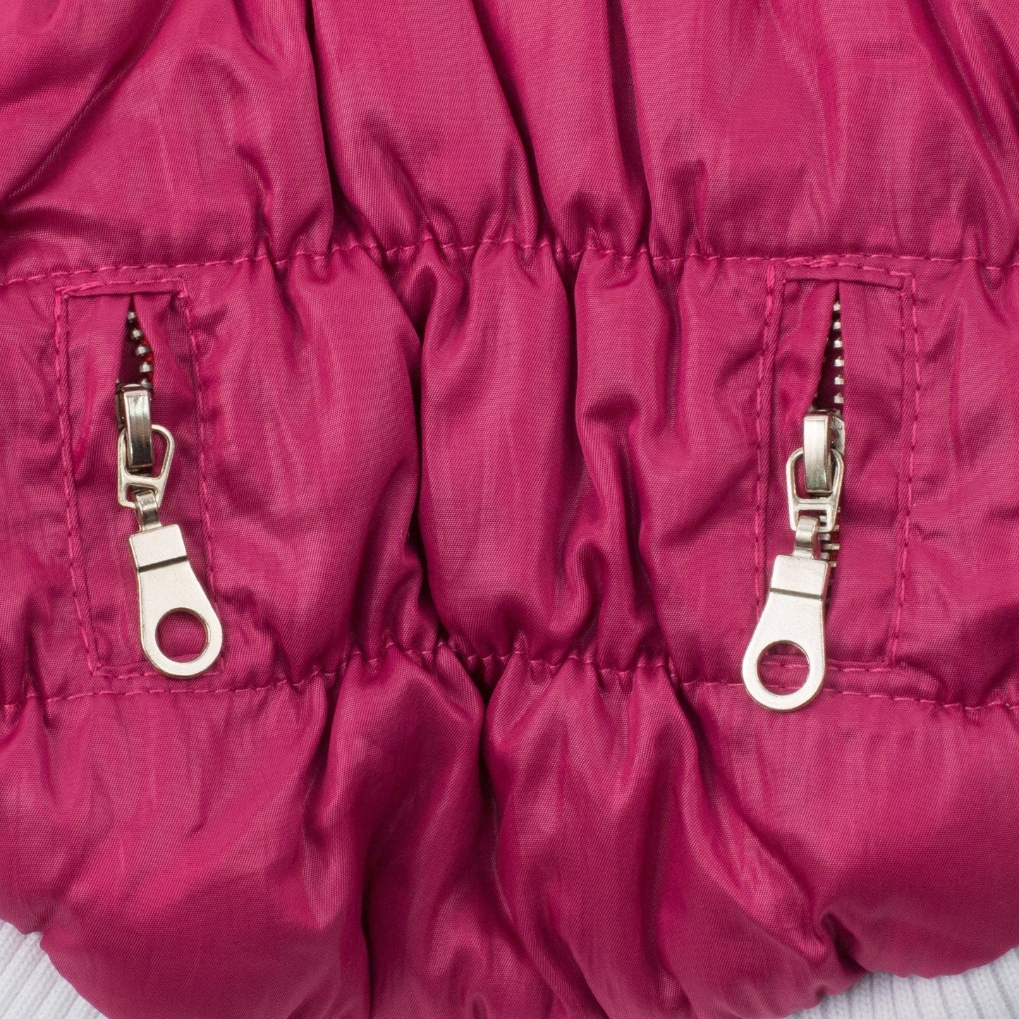 Close-up of a pink puffer jacket with zippers on a white background