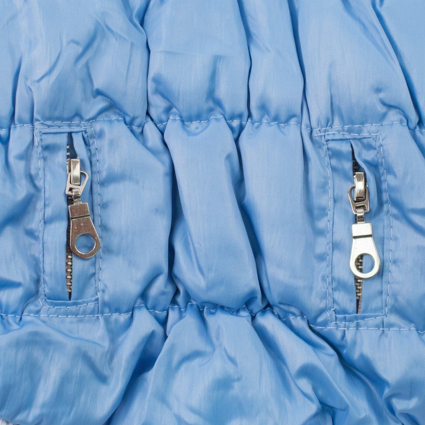 Close-up of a blue jacket with zippers on a white background