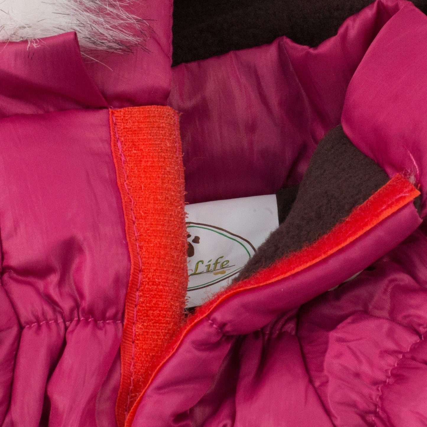 Close-up of a pink jacket with red trim and a visible brand logo.