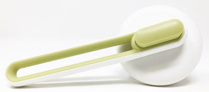 Green and white deshedding tool on a white background