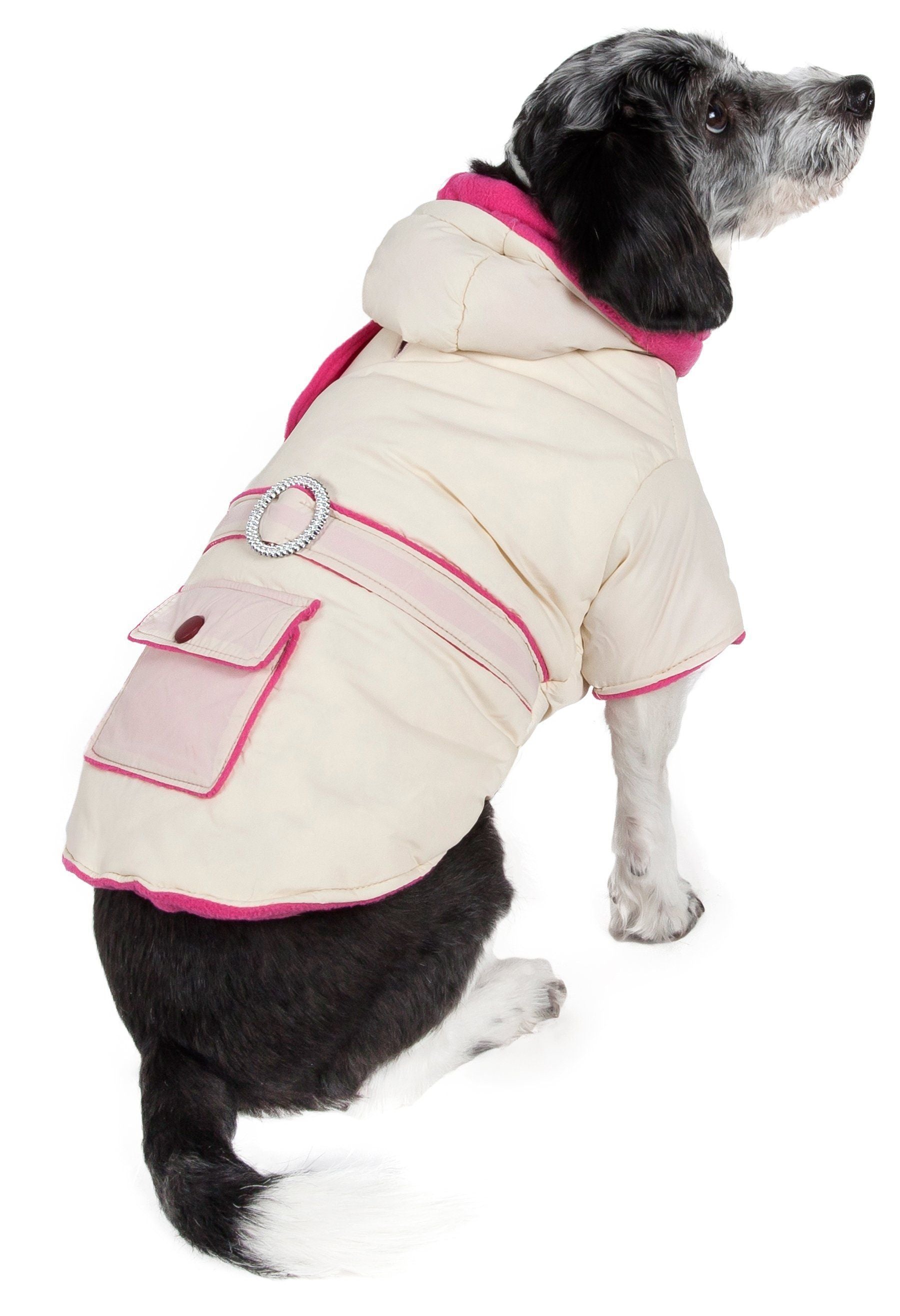 Dog wearing a cream and pink coat with a hood on a white background