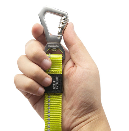 Hand holding a yellow strap with a metal carabiner on a white background