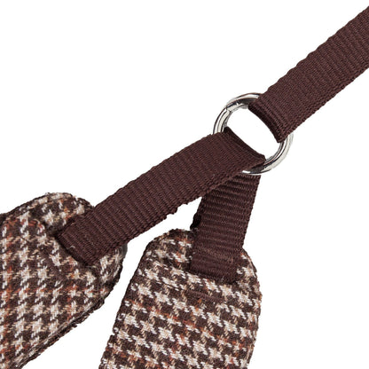 Close-up of a brown houndstooth-patterned dog harness with a metal ring on a white background