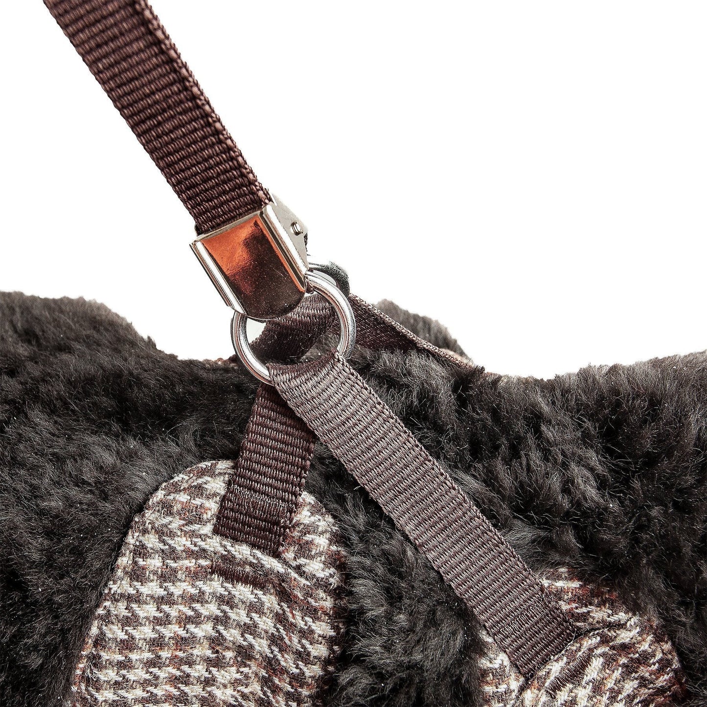 Close-up of a brown strap with a metal buckle on a textured surface.
