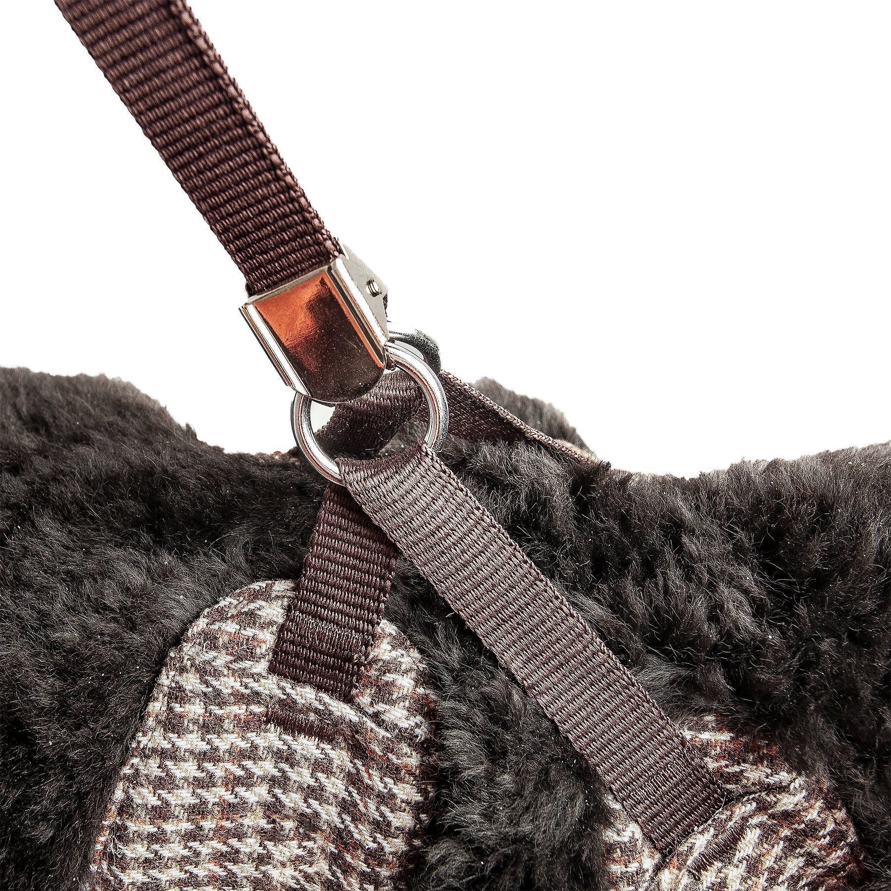Close-up of a brown strap with a metal buckle on a textured surface.