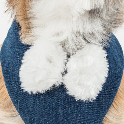 Blue slipper with white fur lining and brown fur trim on a wooden surface