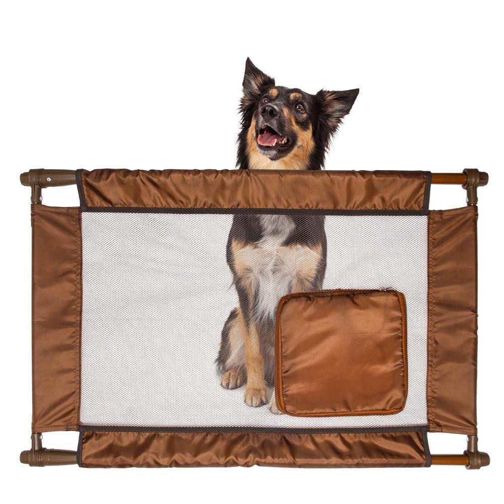 Dog standing behind a brown pet gate on a white background