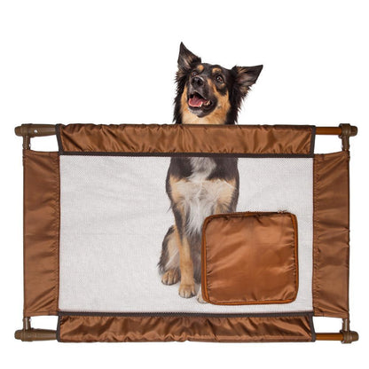 Dog standing behind a brown pet gate on a white background