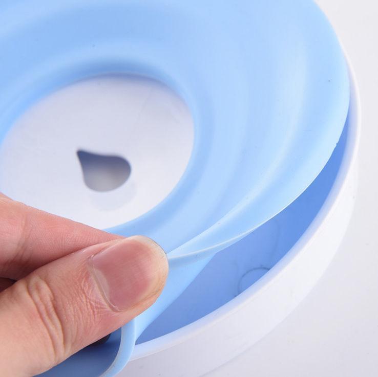 Close-up of a hand holding a blue silicone ring with a white center.