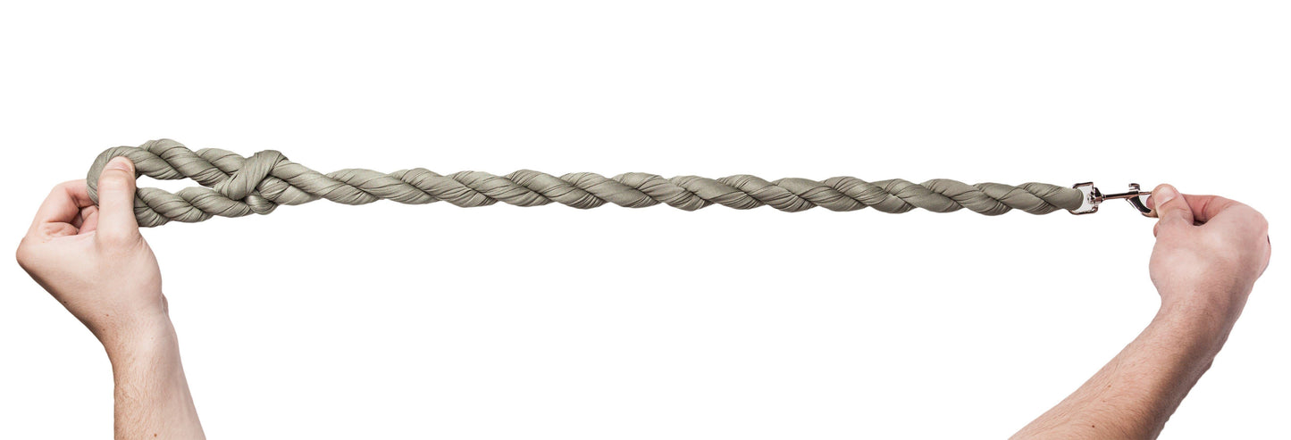 Two hands holding a long braided rope against a white background