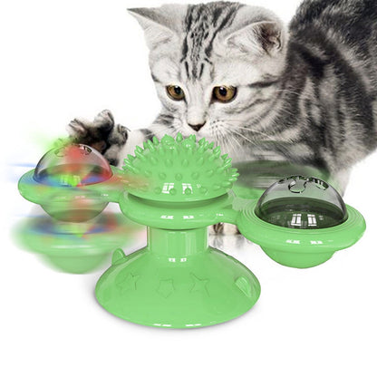 Cat playing with a green interactive pet toy on a white background
