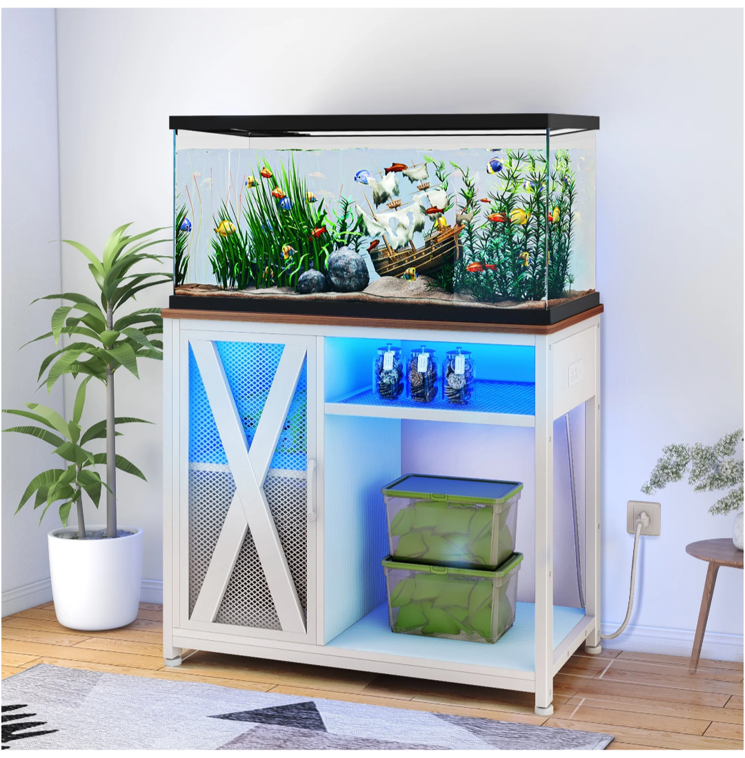 Fish tank with plants and fish on a wooden stand in a room setting.