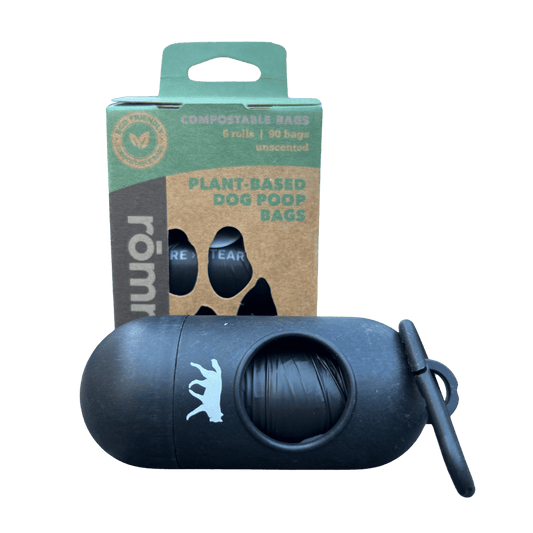 Black dog poop bag dispenser with Rumi compostable dog poop bags packaging on a green background