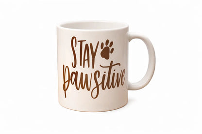 White mug with 'Stay Pawsitive' text and paw print design on a white background