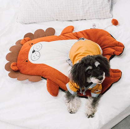 Dog wearing an orange hedgehog costume on a bed