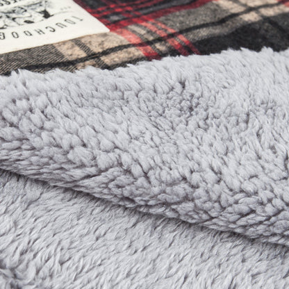 Close-up of a textured gray fabric with a plaid pattern in the background