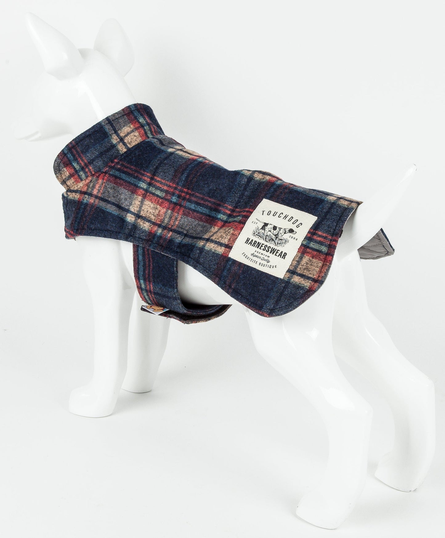 Plaid dog coat on a mannequin with a visible brand label against a white background
