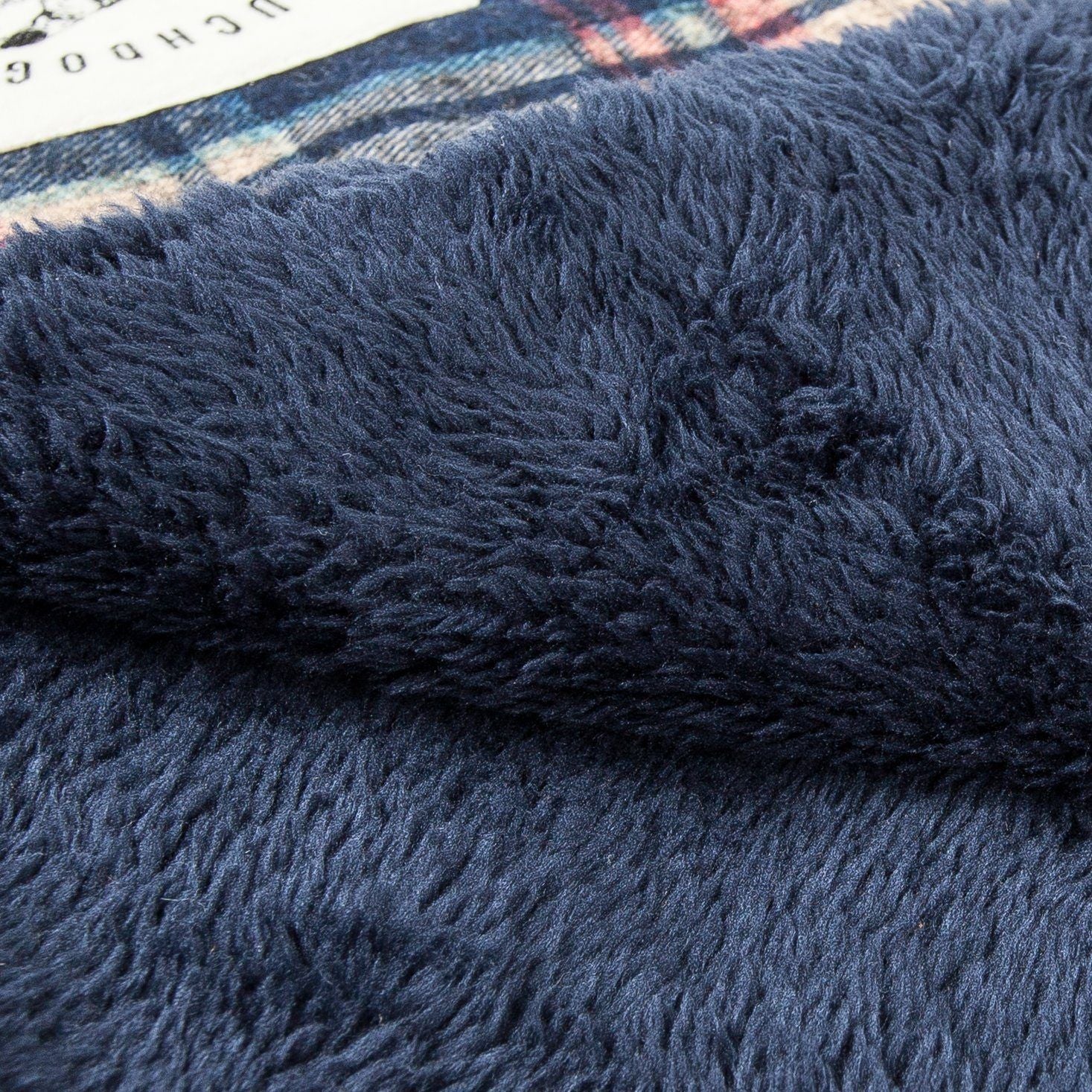 Close-up of a blue textured fabric with a checkered pattern in the background