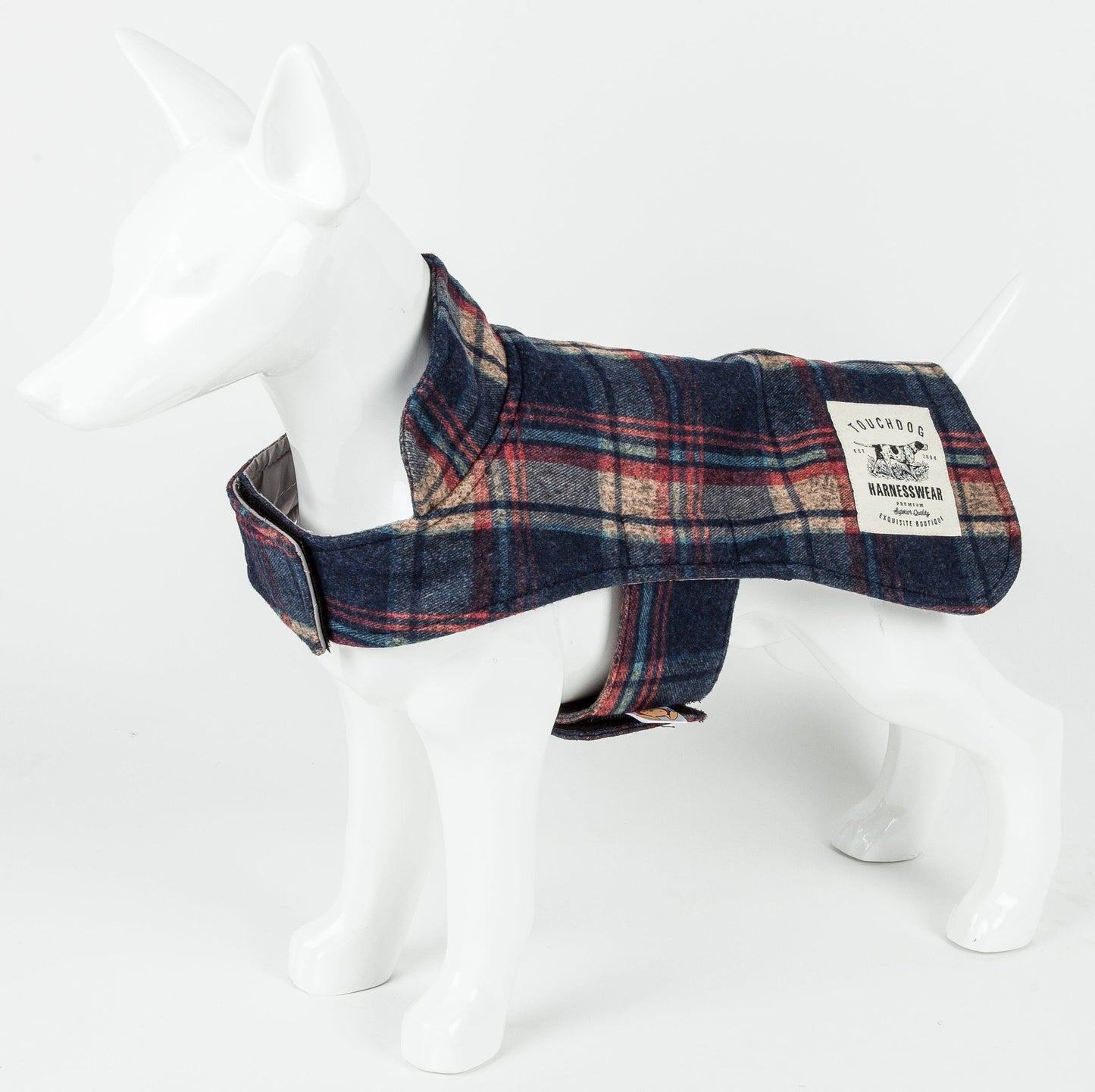 Plaid dog coat on a mannequin with a visible brand label against a white background