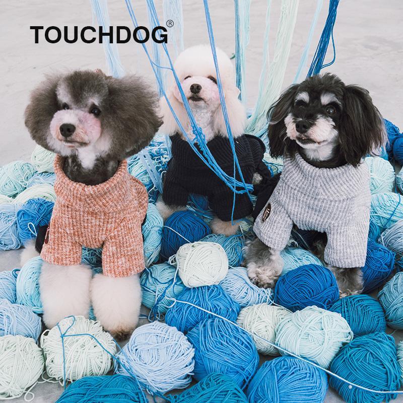 Three small dogs in sweaters surrounded by blue and white yarn balls with 'TOUCHDOG' branding.