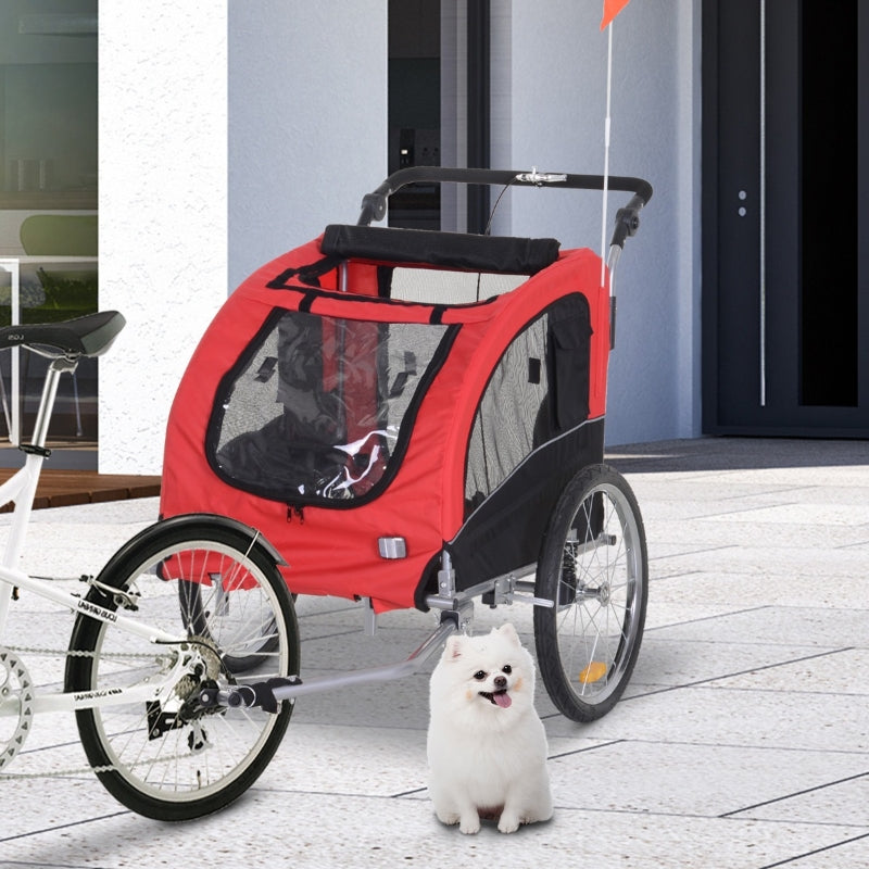 Red and black bicycle pet trailer with a white dog in front of a building.