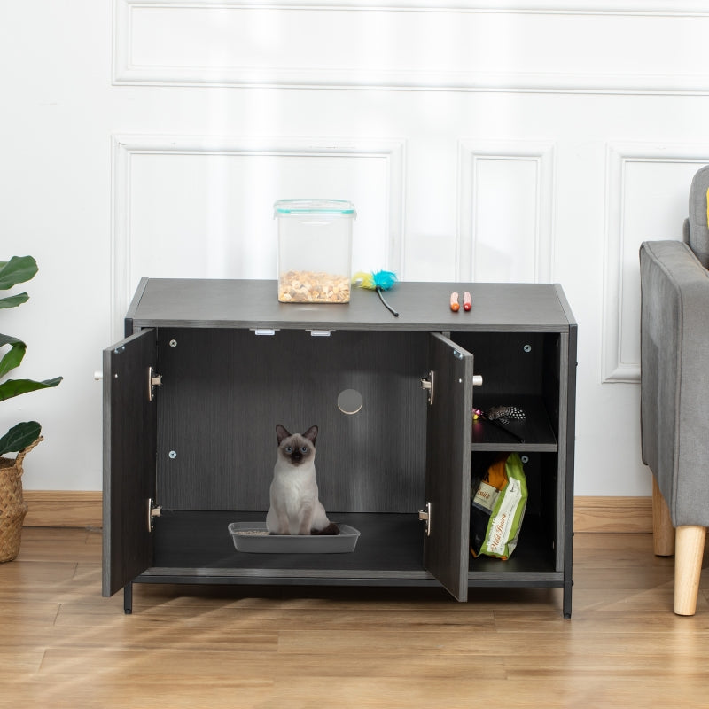 Gray pet enclosure with a cat inside in a room with a plant and furniture.